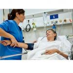 patient in hospital bed with attending nurse